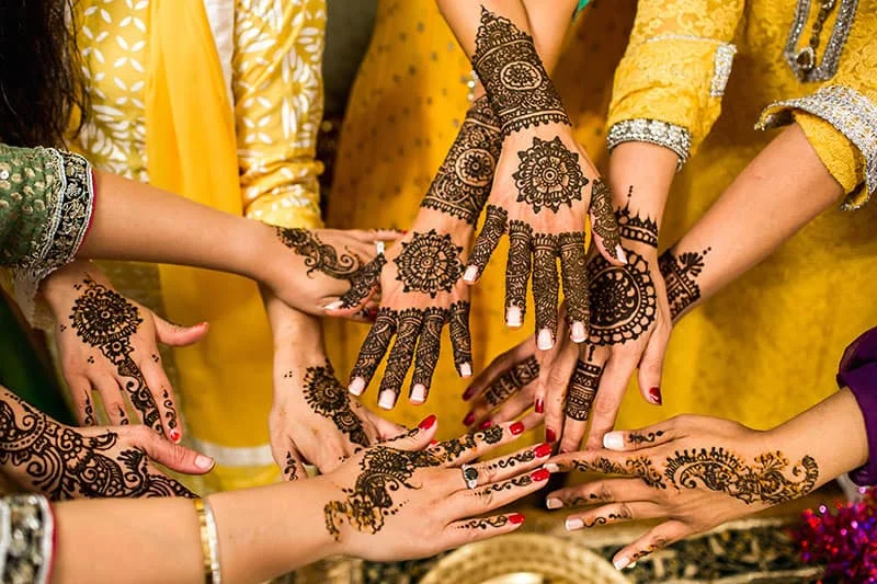 Artists applying mehndi during a sangeet celebration